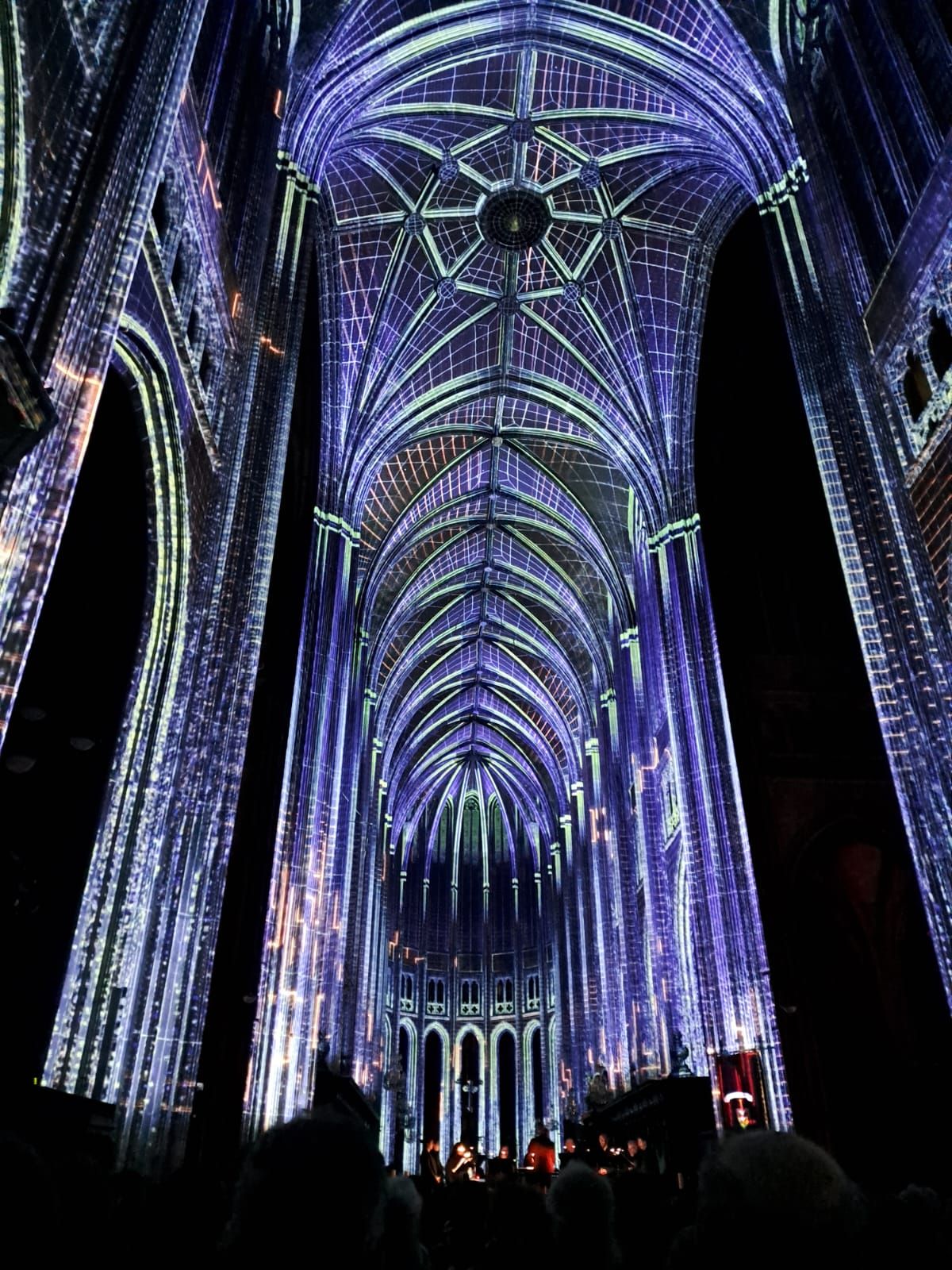 Nef de la cathédrale d’Orléans vue depuis l’arrière pendant Luminiscence : l’enfilade des voûtes éclairées, avec les chanteurs au fond